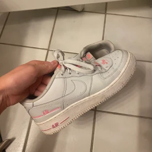 Nike AF1 - Vita Nike Air Force 1 med rosa detaljer! I använt skick men har fortfarande mycket kvar att ge💞