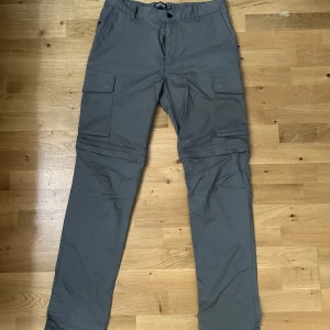 Grå Cargobyxor - Gråa Cargobyxor från Dressmann, aldrig använda, rena och fräscha💯   Storlek: 32/32 Färg: Grå  Märke: Dressmann