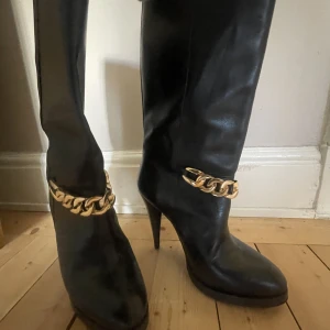 Läder boots - Ett par riktigt feta boots med en guld kedja framtill. Inga defekter och sköna skor! Säljer pga har ett par liknande. De är små i storleken, passar en med 39!