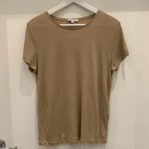 House of Dagmar, Beige T-shirt  - Säljer en beige t-shirt från märket House of Dagmar. T-shirten är i nyskick och är nästan oanvänd.  Storlek: S