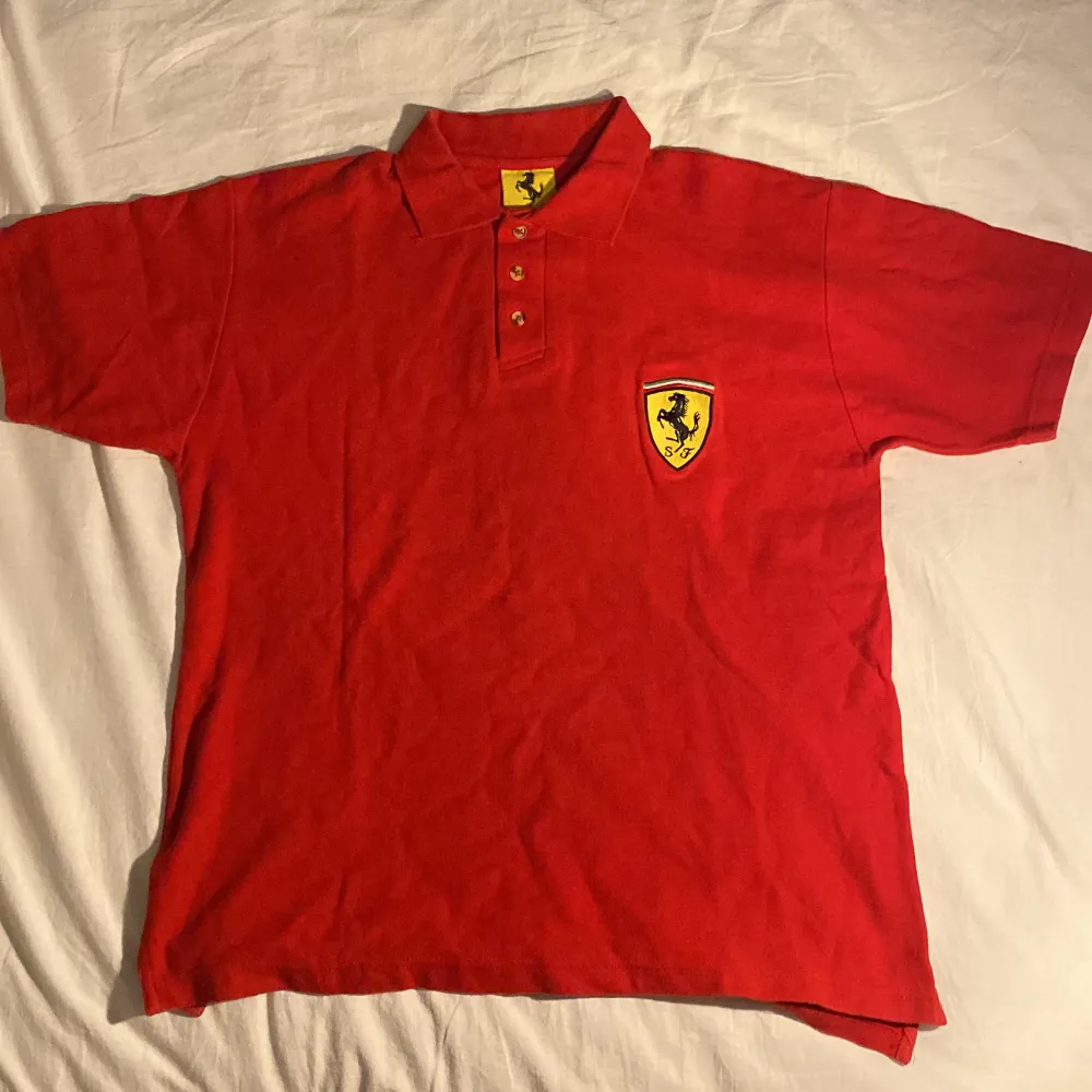 En Röd Ferrari Pikétröja i fint skick storlek Medium, inga skador, märken eller fläckar. Köpt för 800kr mitt pris 250kr. Kan skicka men finns att köpa i Uppsala. T-shirts.