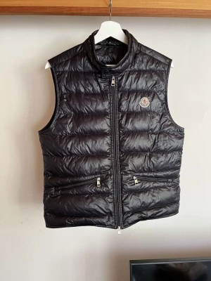 Moncler gui navy - Säljer min moncler gui väst som är i skick 9/10 finns inga fel på den. Det finns kvitto och box från moncler som följer med vid köp.  Västen är i storlek 1