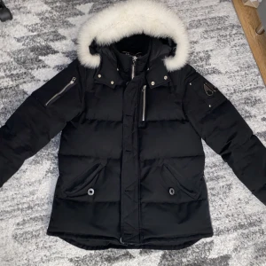 Moose Knuckles 3Q Svart - En svart moose knuckles 3q jacka i storlek M (passar även S) med vitt päls, äkta och finns även kvitto (finns bild på annonsen) o tags kvar. Använd 3 vintrar men har inga täcken på användning alls. Köptes för 10 500kr.  Priset är lagt i sista pris