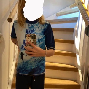 Blå badtröja 💙🌊 - Säljer denna fina blå bad tröja med texten ”EAT. SURF. SLEEP. REPEAT.” på magen 💙💗. Köpt på Kappahl i storlek 146/152 💕. Tecken på användning finns 🤍. 