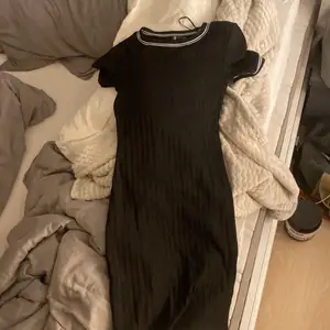 En ribbad svart längre klänning från H&M! Den har vita detaljer upp mot urringningen