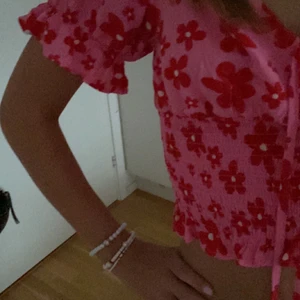 Rosa blommig topp från new yorker  - Jätte fin rosa topp med röda fina blommor köpt på new yorker, säljer pågrund av att den inte riktigt känns som min stil! Icke använd utan bara testad! Som i nyskick, kostade 149 kr i butik! Kontakta mig vid intresse <333 köparen står för frakten!! 