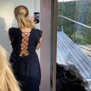 Hålbroderat klänninh - Marinblå från Zalando med assnygg rygg