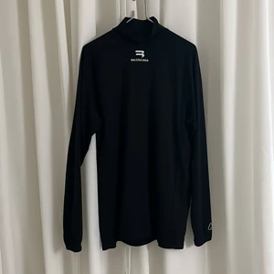 Balenciaga långärmad - Långärmad tröja med hög krage från Balenciaga. Små trådar sticker fram på framsidan, syns knappt