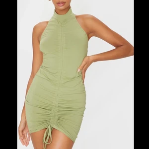 Haltherneck klänning - Så fin pastell grön klänning med halther och öppen rygg! Går att dra åt längst ner på klänningen för att justera lös/tight samt längd på klänningen!