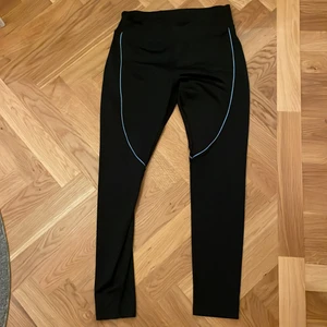 Svarta helt oanvända träningsbyxor 💪🏽🖤 - Svarta träningsbyxor som är helt oanvänd och har ett blåttsträck som detalj!💙🖤 Säljer för endast 40 kr! 