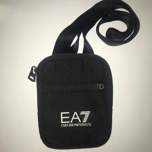Emporio Armani Axelremsväsra - Emporio Armani Axelremsväska jätte fint skick, finns en defekt se bild 2 annars inget att anmärka på.  Bredd 11 Djup 2  Höjd 15  Kom med bud 