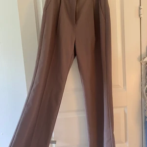 Kostymbyxor  - Brun/grå kostymbyxor från nakd, jätte snygg pass form och långa i benen 