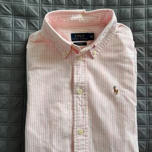 Rosarandig skjorta i figursydd passform från Ralph Lauren. Använd en gång. Storlek xs. Köparen står för frakten 