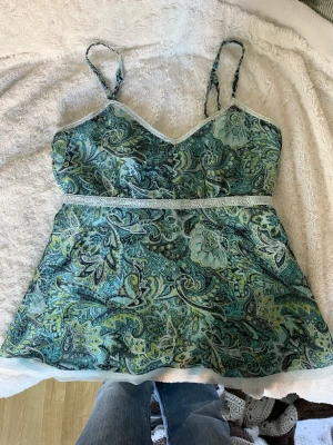babydoll linne - världens sötaste babydoll linne med turkos paisley print. passar perfekt för sommar, blir så fint till lowrise byxor eller kjol!!  sitter bäst på 36/38 men hade nog kunnat passa 40 också!