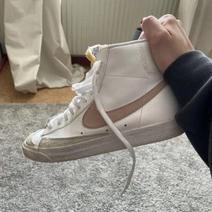 Nike Blazers  - Säljer nu mina Nike Blazers Mid 77 då de har blivit försmå för mig! Vita med rosa märke. Jättebra skick då de knappt är använda, skriv för fler bilder!✨