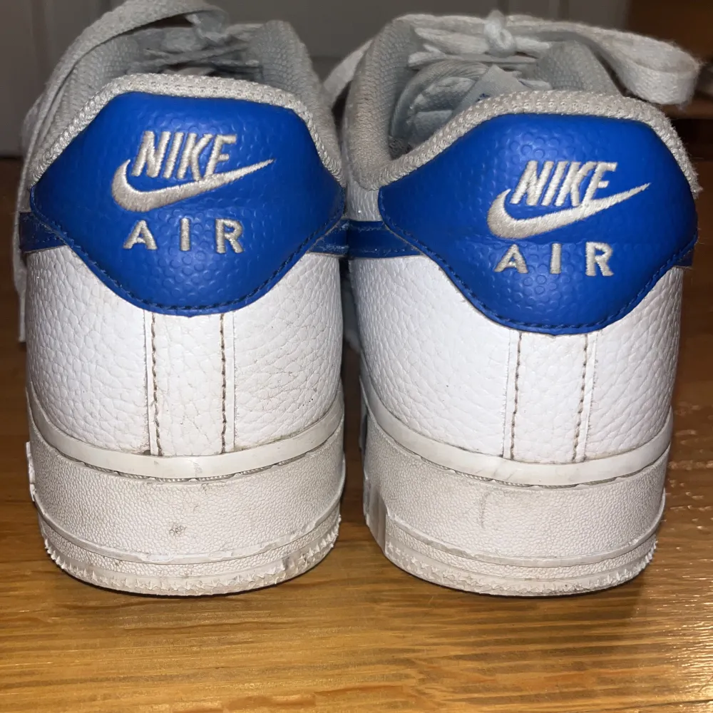 Ett par snygga Nike air force 1 med blått nikemärke. Köpta för ca 1300kr. De har några defekter som syns på sista bilden (skrapmärkerna är på insidan av skon så inget man tänker på).😊. Skor.