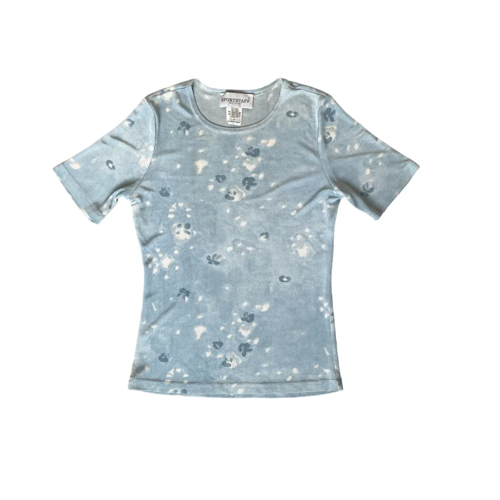 En ljusblå tröja med mönster på🐚. T-shirts.