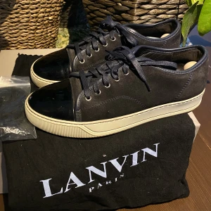 Lanvin Patent Cap Toe Sneaker Navy Blue - Hej, säljer ett par riktigt snygga marinblå Lanvin Cap Toe sneakers. De är i väldigt bra skick, dustbag samt extra snören medkommer vid köp. Storlek 8 vilket motsvarar 42/43. Nypris runt 4000kr. Priset är inte hugget i sten. Hör av dig vid intresse!