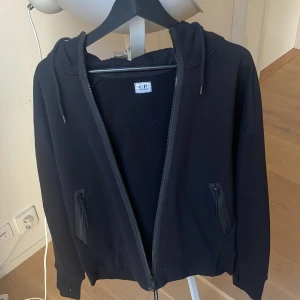 Cp company google zip hoddie black - Väldigt bra skick , knappt andvänd, extra knappar medföljer  Storlek L, nypris 2499kr skriv vid fler frågor 