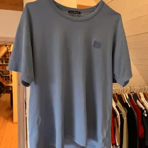 Somrig blå acne t shirt, snygg till sommaren☀️ Har några småhål längst nere men är knappt synbart samt liten fläck på. Skriv om du vill ha fler bilder Nypris: 1000kr