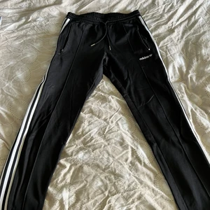 Adidas byxor - Svarta adidas byxor. Dragkedjor på fickorna. Vänstra dragkedjan har gått sönder men går att fixa. Annars är dom i bra skick. Modellen går rakt ner hela vägen. 