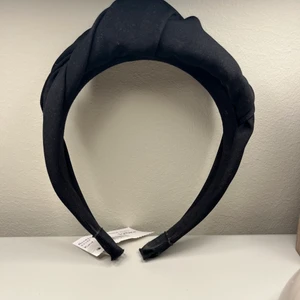 Svart diadem/hårband med knut - Säljer ett svart tyg diadem/hårband med knut inköpt på Arkivet. Prislappen är på då det tyvärr inte passade min huvudform.