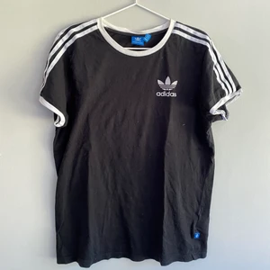 T-shirt - adidas  - (Tryck inte ”köp nu” skriv istället till oss)  Svart T-shirt med tre sträck längst det båda ärmarna och adidas logan på bröstet. Frakten står du för själv💕