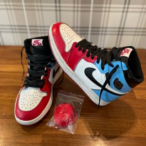 Nike air Jordan 1 Retro High OG Fearless - Ganska använda Jordans med skador framme vid tårna och lite skrap märken bak på en sula. Men ser väldigt bra ut på bra håll. Kartongen är i dåligt skick. Storlek 39.