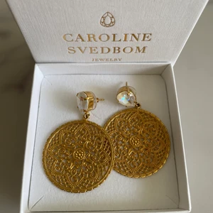 Caroline Svedbom Örhängen - Säljer mina fina Caroline Svedbom örhängen, knappt använda, så som nya, nyskick, nypris var 895 kr (köpta på Raglady på Kungsmässan) Stenen är vit