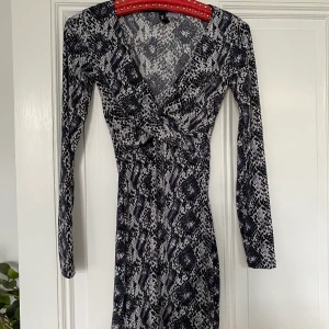 Klänning - Tajt kortklänning i bra skick, köpt från hm några år sedan. Den är mörkblå, lite svart och vit. Aldrig använd endast prövad. Säljer för att det inte är min stil och har därför aldrig använt den. Frakt tillkommer