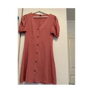 Rosa klänning med knappar framtill från H&M i storlek 36. Använd ett fåtal gånger. Nypris 150 kr säljes för 50 kr+frakt
