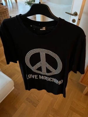 Moschino T-shirt  - två väldigt små hål längst ner på framsidan som knappt syns.