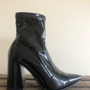 Boots i lack - Svarta sockboots i lack, strlk 37. Klackhöjd 8,5 cm. Använda fåtal ggr.   Hämtas på Kungsholmen eller kan mötas upp i centrala sthlm. Frakt tillkommer vid önskemål om att skicka per post. 😊