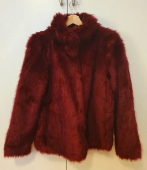VERO MODA Jacka Fuskpäls Vintöd Strl. M  - Varm och fin kort jacka från Vero Moda i vinröd kulör. Fuskpäls. Storlek M (38), men är liten i storlek och passar mer till S (36). Jackan är i ganska bra skick. Kan hämtas av vid möte på Södermalm eller Norrmalm (Stockholm).