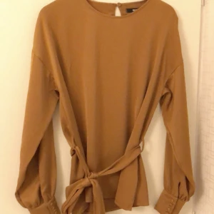 Elegant blus - Elegant senapsfärgad blus i fint mjukt material. Flexibel i storlek då den är väääldigt stor i Storlek. Jag är en XS-S men den är väldigt oversize på mig. 