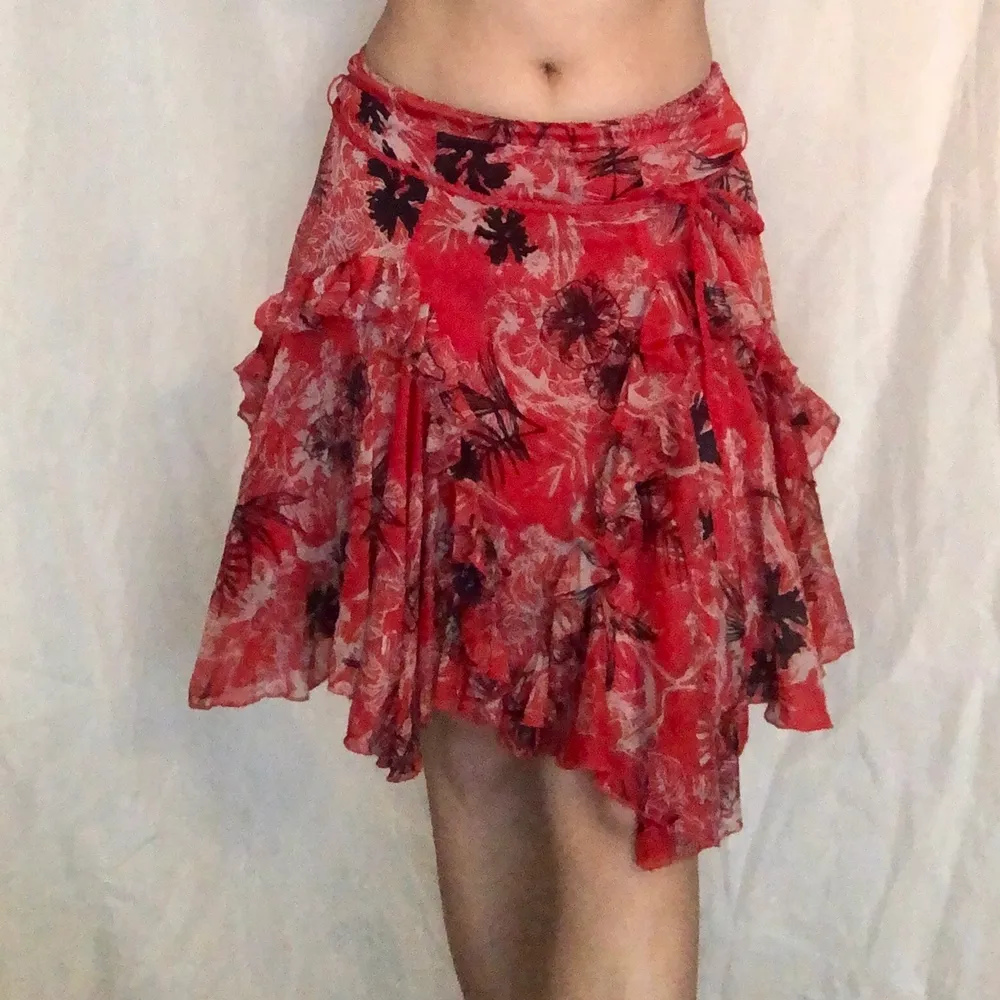 Röd kjol med volanger, knytbälte och dragkjedja på sidan. I superfint skick, storlek 38 och från not the same NTS. . Kjolar.