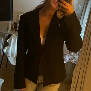 Svart kavaj - Så fin svart kavaj från vila. Knäpps med ett litet spänne och har slits vid händerna. Köpt secondhand. Storlek L men skulle säga att den är som en S💖💖