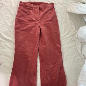 Rosa/ röda byxor monki strl 34 - Monki byxor i samets liknade material hög midjat coropat i benen 
