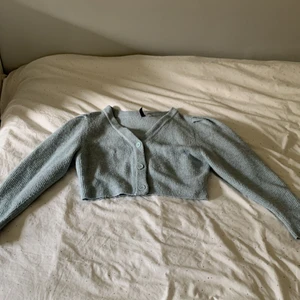 Stickad kofta - En söt croppad kofta med puff ärmar från Hm. Den är i fint skick. Säljer då den tyvärr inte passar mig längre. Frakt tillkommer!