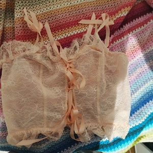 Rosa spets top med snörning - En söt puderrosa top i spets med snörning fram. Endast prövad och sen legat i garderoben. Inte min stil helt enkelt. Storleken är M/L.