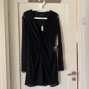 Långärmad spetsklänning - Jättesnygg spetsklänning i omlottmodell. Långärmad. Aldrig använd. Knälång.