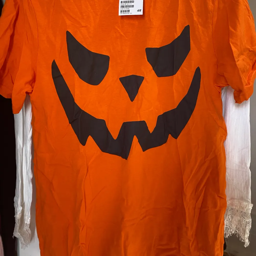 En orange T-shirt med pumpa ansikte. Passsr bra till halloween. Storbild storleken. . T-shirts.