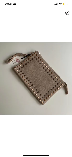 Kuvertväska - En oanvänd fin kuvertväska ifrån Tiamo. Tre mindre fack i väskan varav det största har en dragkedja. Ett fack på baksidan med dragkedja. Perfekt för festligare tillfällen!  Mått: Längd 31 cm Bredd 20 cm  Aldrig använd, lappen kvar. 