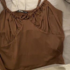 Topp - En jätte fin brun topp med snörning i mitten som man kan spänna åt. Används få tal gånger är i bra skick💗✨passa på nu när de är gratis frakt 🥰