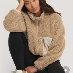 Teddy jacka NA-KD  - Croppad teddy jacka från NA-KD i strl 32 jackan kan bäras på två sätt då man kan ha den med teddy sidan utåt eller innåt.