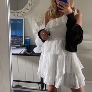 Klänning - Säljer en superfin vit klänning som passar till studenten eller skolavslutningen. Klänningen är endast använd 1 gång och den har inga ärmar men knyts på ena axeln.