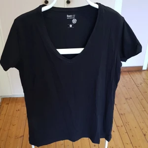 T-shirt med V-krage. - Svart T-shirt med korta ärmar. Storlek XL