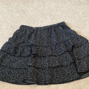Volangkjol i storlek S - Svart volangkjol med vita prickar i storlek S. Använd några gånger men fortfarande som ny 