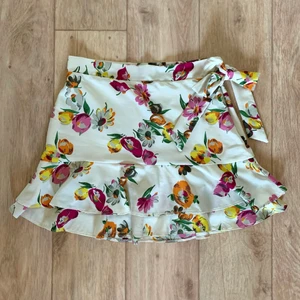 Vit blommig kjol storlek S från Zara - En blommig kjol från märket Zara. Stängs med dragkedja i sidan. Storlek S. Fint skick och sparsamt använd. Material: 100% polyester.