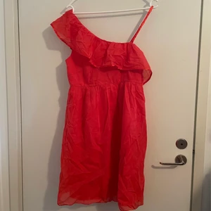 Vila korall rosa orange klänning medium - Jättefin oanvänd klänning från Vila i storlek medium. Fantastisk fin färg som är svår att fånga på bild (mer korall i verkligheten).   Dragkedja och krok i sidan.  Går halvvägs ner på låret på mig som är 175cm lång  2 lager tyg, silkeskjol närmast kroppen, skirt tyg längst ut.